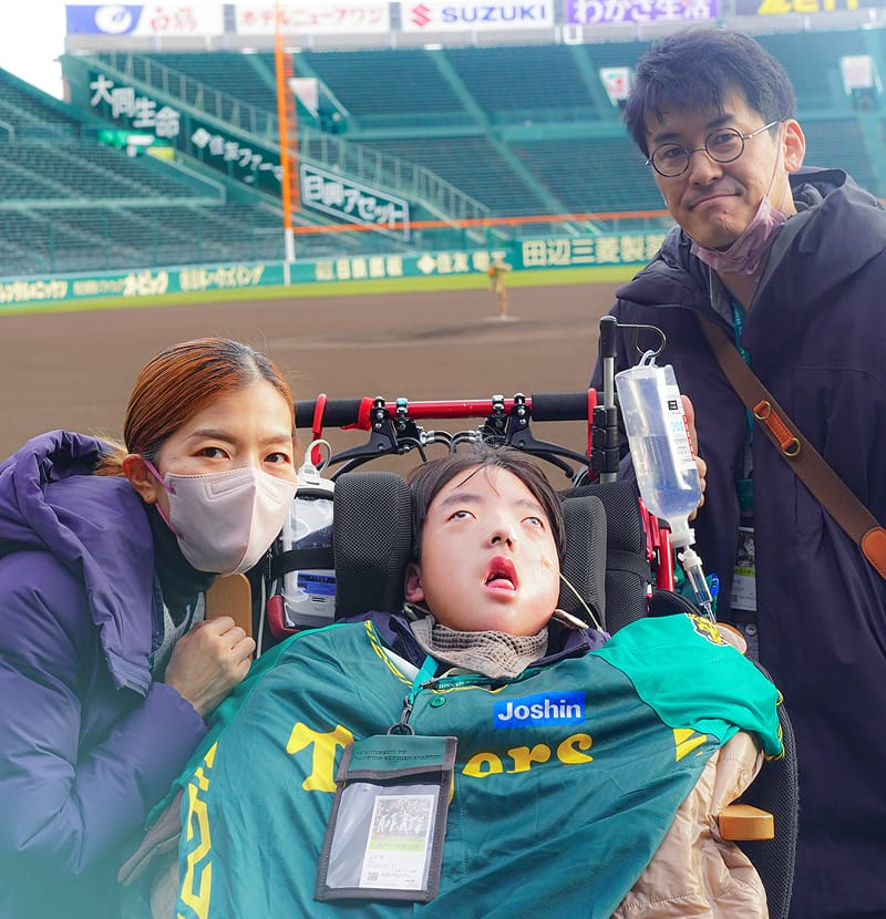 車いすの子どもとスタッフが一緒に野球場を訪れている様子
