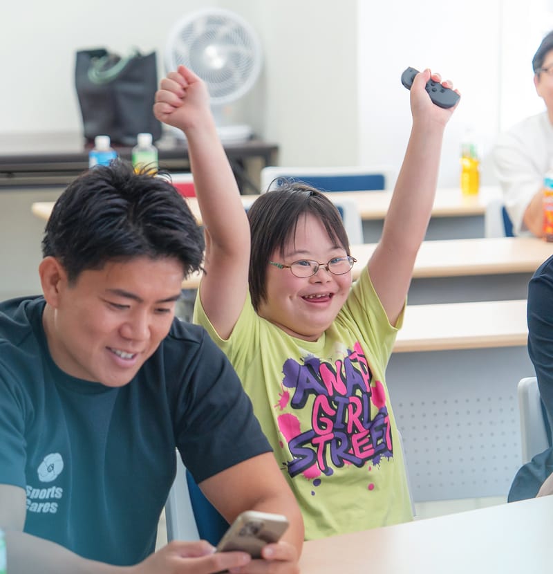 車いすの子どもとボランティアが一緒に工作を楽しむ様子