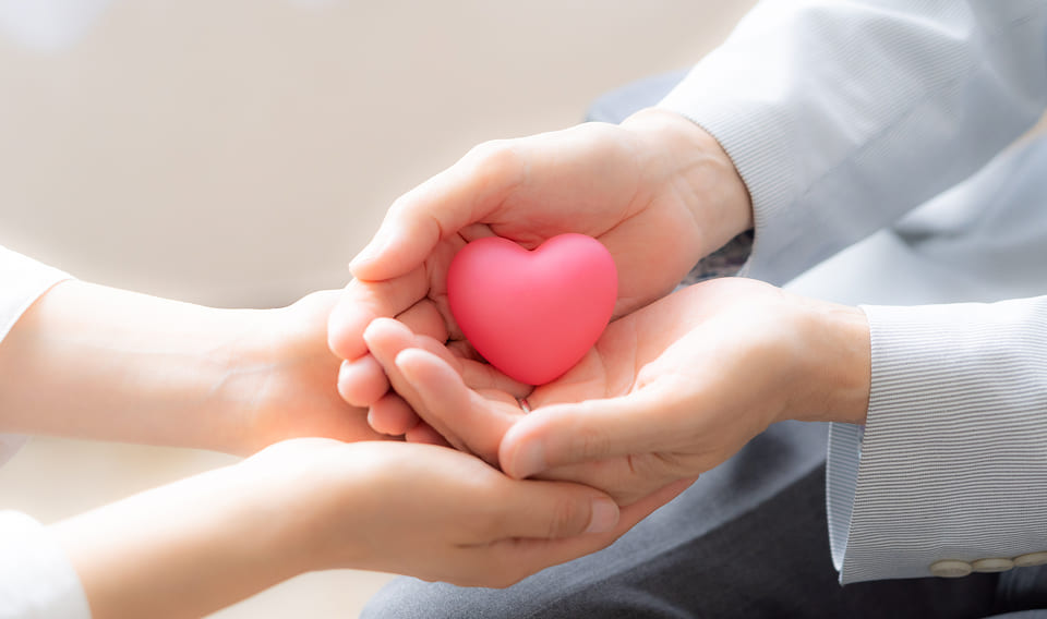 ハート型のオブジェを手渡す様子(ご寄付のイメージ)