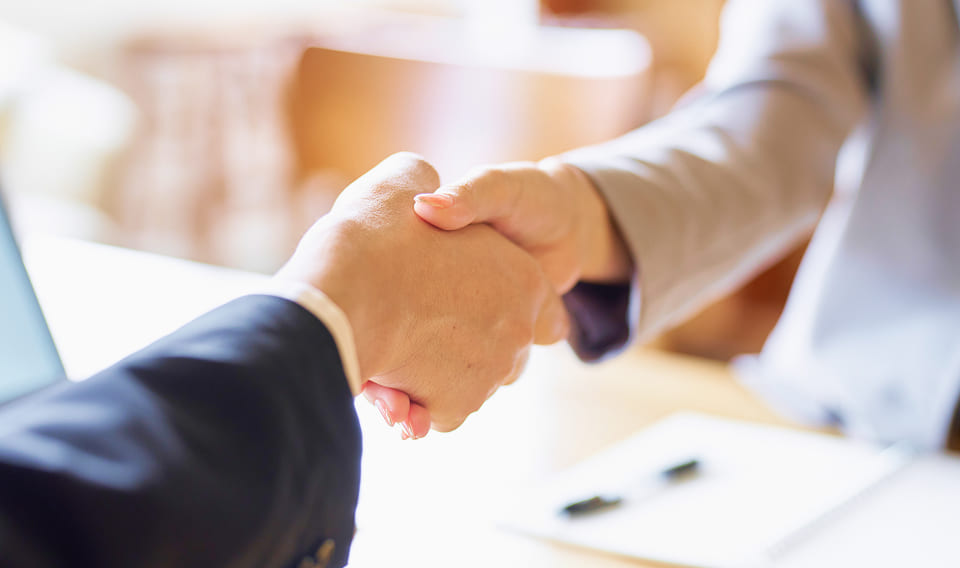 ビジネスパーソン同士が握手する様子(イベント連携のイメージ)